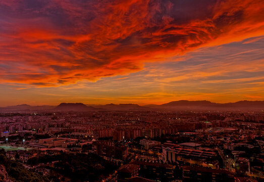 Cielo con enormes nubes de color rojo al atardecer sobre la ciudad de Alicante