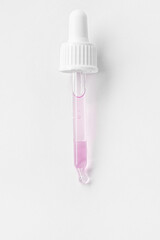 Cosmetic pipette with pink gel, serum, serum on a light background.