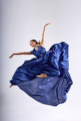 dancer Jumping in Air in Fluttering Dress Graceful Ballerina Dancing in Blue isolated white...