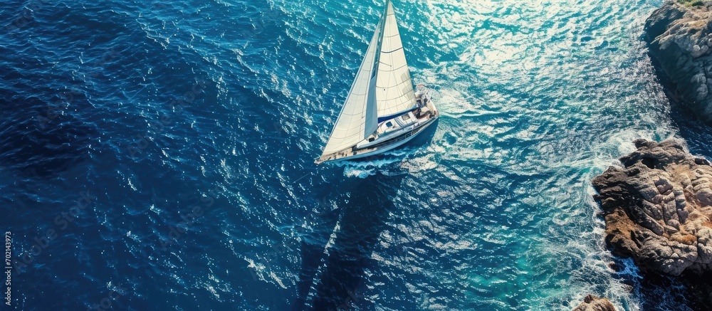 Poster aerial drone ultra wide photo of beautiful sailboat cruising deep blue open ocean mediterranean sea.