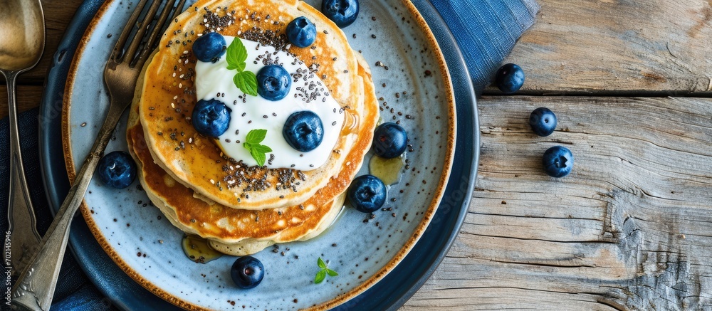 Poster Chia seed pancakes with yogurt and blueberries on plate closeup view. with copy space image. Place for adding text or design