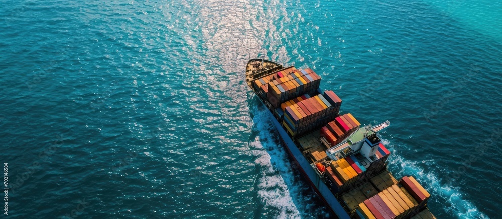 Poster aerial drone photo of huge container tanker ship carrying truck size colourful containers in deep bl