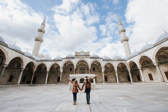 Couple of tourists holding hands posing inside majestick Suleymaniye mowque of Istanbul Turkye