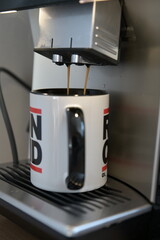 Coffee flows from a fully automatic coffee machine into a coffee pot