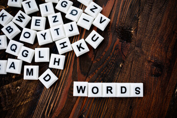 words and pile of various letters scattered on wooden background 