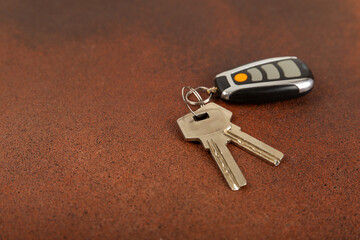 Car key with key fob on a colored background. Buying or renting a car. Car gift. Stylish keychain with car key. Place for text. Copy space.