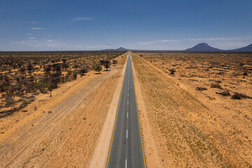 Fototapeta na wymiar Aerial drone shot of straight and empty road from Namibia, Africa.