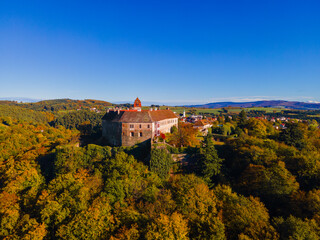 Fototapeta na wymiar Ancient castle in fall forest colors.