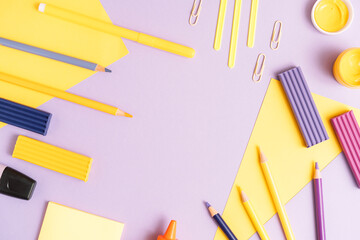 School stationery scattered on purple background.
