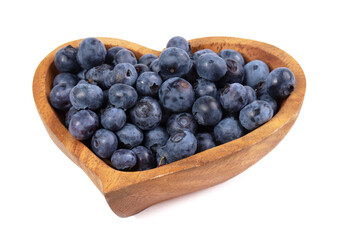 Garden blueberries in a wooden plate in the shape of a heart on a white background. I love berries.