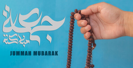 Jummah Mubarak blessed happy Friday Arabic calligraphy, Selective focus image hand of Muslim woman...