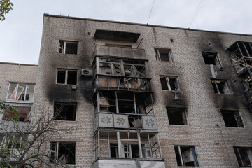 Fototapeta na wymiar A multi-story residential building, heavily damaged after artillery shelling