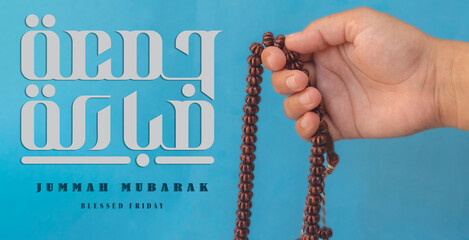 Jummah Mubarak blessed happy Friday Arabic calligraphy, Selective focus image hand of Muslim woman...