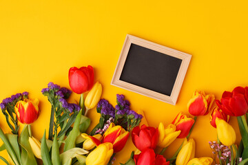 Bouquet of colorful tulip flowers and wooden frame with space for text, invitation card. Hallo spring concept, seasonal holiday, 8 march International woman day, Mother day, Birthday