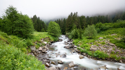 River runs gently through Black Sea Karadeniz region of Turkey, through lush greenery and mountains. Beautiful Black Sea highlands scenery with green forest and mountains. Long exposure shot