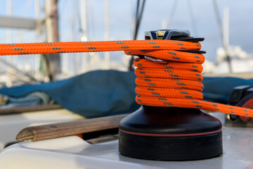 Yacht winch with orange rope on sailing boat. Yachting concept.