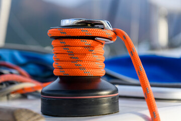 Yacht winch with orange rope on sailing boat. Yachting concept.