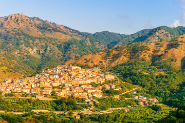 Obraz premium highland landscape of italian town between amazing green mountains with scenic sunset cloudy sky on background