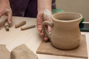 Clay, pottery or hands in designer workshop working on an artistic cup or mug mold in small business studio. Hand of creative artist or worker manufacturing handicraft products in sculpture