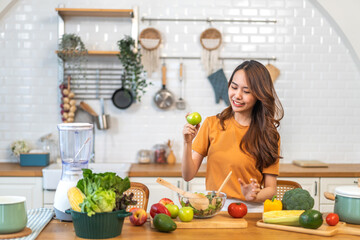 Portrait of beauty body slim healthy asian woman big smile cooking and preparing vegan food healthy holding apple, green apple, dental, teeth, fruit in kitchen at home.Diet.Fitness, healthy food