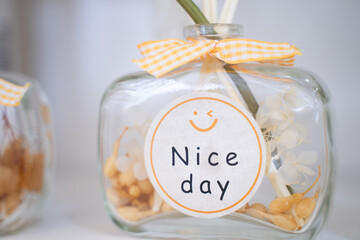 Glass jar of dried flowers with Nice Day message sticker