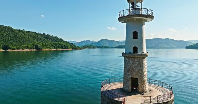 Aerial footage of Xin'anjiang Reservoir natural landscape in Hangzhou. Drone flies over the lighthouse to photograph green mountains and clear lake water.