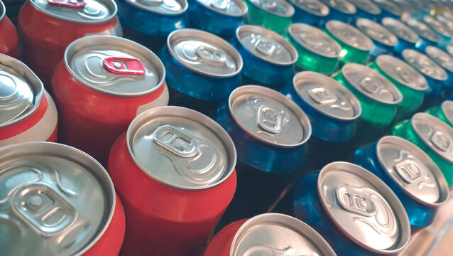 Rows of colorful metal cans with soda drink in shop