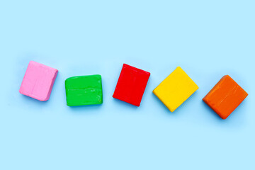 Colorful plasticine clay on blue background.