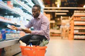 Young african man buying in grocery section at supermarket