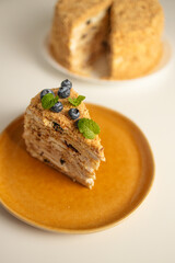 Homemade baked cake Napoleon, Millefeuille. Delicate custard cake garnished with berries and mint. On a gray concrete stone background.