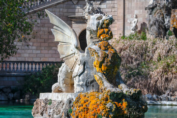 Fototapeta na wymiar Majestic sculpture of dragon in stone . Fountain in park of Barcelona
