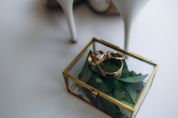 close up view of white flowers, wedding rings in rustic box with plants inside
