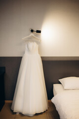 Fototapeta na wymiar Wedding day bride's dress hanging