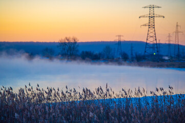 A beautiful and calm scene of a winter morning. High voltage power lines in foggy fog. Peaceful...