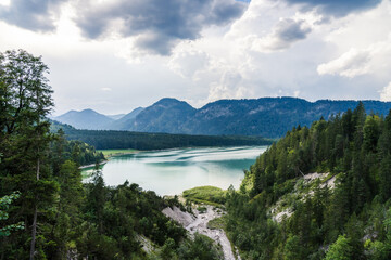 Fototapeta na wymiar Sylvensteinstausee in the bavarian Alps in summer with a thunderstorm coming and forest in the foreground