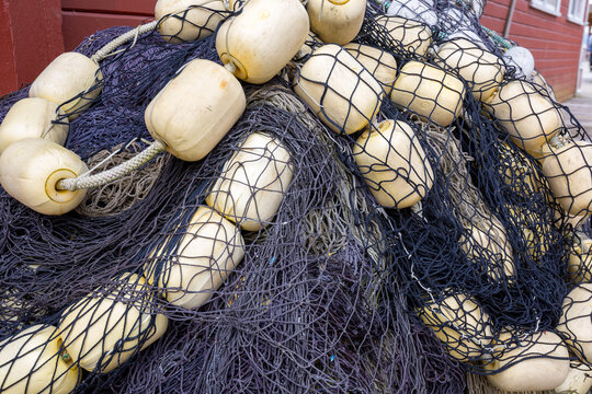 Blauw visnet  met gele drijvers van vissersboot op de kade
