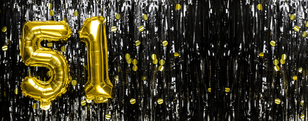 Gold foil balloon number number 51 on a background of black tinsel decoration. Birthday greeting card, inscription fifty-one. Anniversary event. Banner. - obrazy, fototapety, plakaty