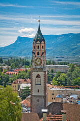 Massiver Kirchturm vor Talblick mit Bergpanorama im Hintergrund - obrazy, fototapety, plakaty