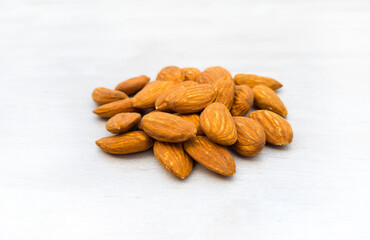 Raw Almonds with, Prunus dulcis. dried fruits for happy
Tu Bishvat.
Healthy natural food with lots of minerals and vitamins. On a white background wooden texture. with free space for text
