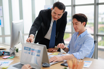 Fototapeta premium two Asian businessperson colleagues discussing with computer in office.