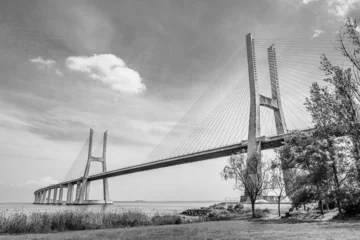 Papier Peint photo autocollant Pont Vasco da Gama Vasco da Gama bridge in Lisbon, Portugal  cable stayed bridge flanked by viaducts and rangeviews that spans the Tagus river in Parque das Nacoes, the second longest bridge in Europe in black and white