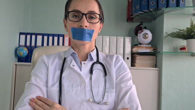 Doctor with tape and mouth taped. Medical confidentiality and non-disclosure of diagnosis concept