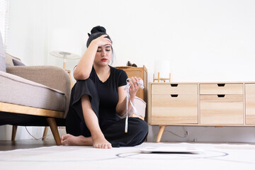 Depressed sad overweight woman with measuring tape sitting on floor near scale