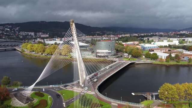 Cinematic aerial perspective of Pontevedra city. Famous travel destination in Galicia. River Lerez and Puente de Los Tirantes. Drone ascending close to the bridge
