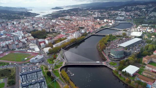 Cinematic aerial perspective of Pontevedra city. Famous travel destination in Galicia. River Lerez and Puente de Los Tirantes. At left is the downtown of Pontevedra. Panoramic view of all region