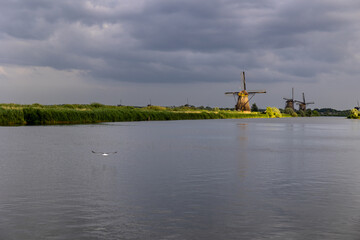 Beautiful wooden windmills at sunset in the Dutch village of Kinderdijk. Windmills run on the wind. The beautiful Dutch canals are filled with water. Beautiful sunset. - 702245367