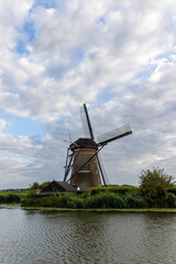 Beautiful wooden windmills at sunset in the Dutch village of Kinderdijk. Windmills run on the wind. The beautiful Dutch canals are filled with water. Beautiful sunset. - 702245376