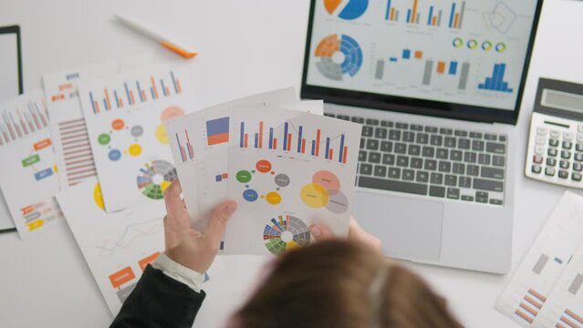 Businesswoman dressed in stylish suit working with documents on her computer in modern office A professional manager focused on solving business problems and conducting financial analytics.