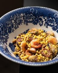 Savoring Sardegna: Dark and Elegant Plate of Sardinian Fregola, Chef's Seafood Symphony