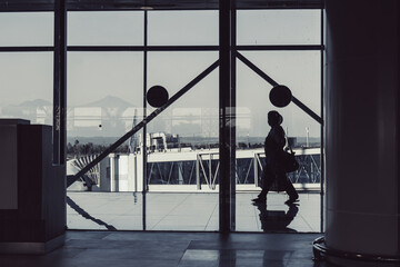 Airport terminal. Silhouettes of passenger and windows with the view of runaway and airplane